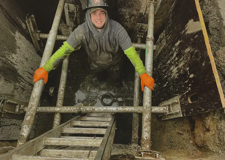 sewer professional working in sewer trench