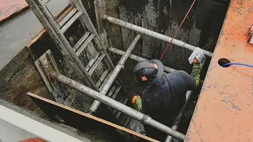 sewer tech working on underground sewer pipes