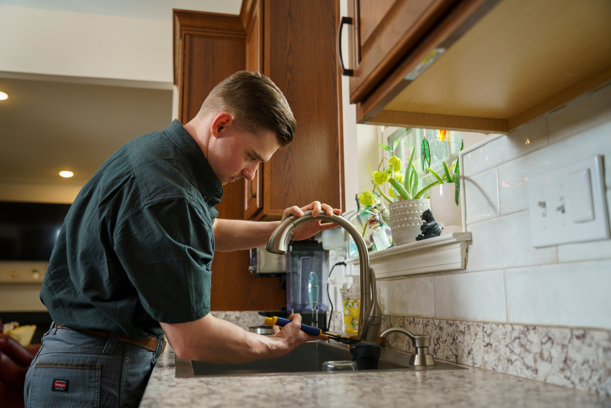 repiping specialist working on kitchen plumbing